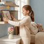 Child placing a thoughtful room decor gift on a bedroom shelf