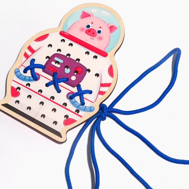 Wooden toy with a pig design and blue string on a white background