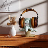 Decorative headphone stand with a cartoon face on a wooden surface