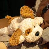 White teddy bear with brown accents held by a person wearing a coat.