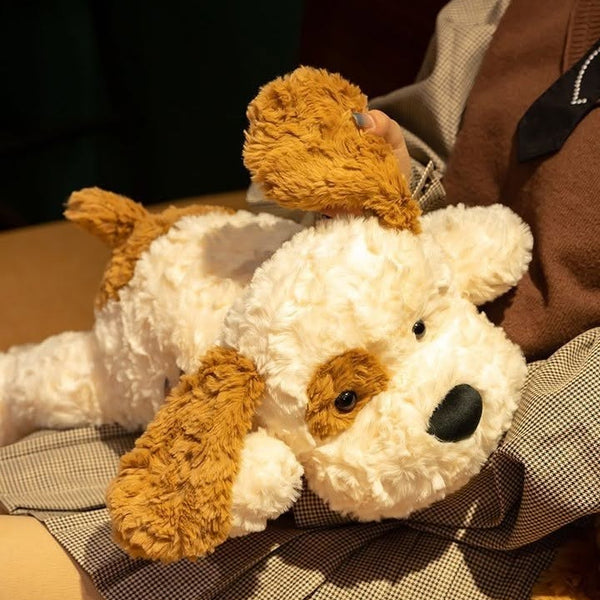 White teddy bear with brown accents held by a person wearing a coat.