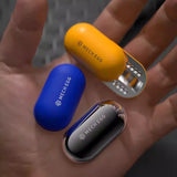 Three MECH EGG products in yellow, blue, and silver on a hand.