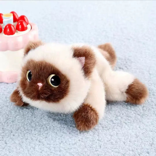 Plush toy cat with brown and white fur on a light gray surface