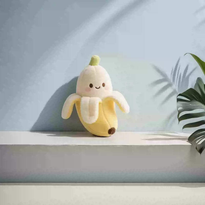 Plush banana toy on a white surface with a light blue background