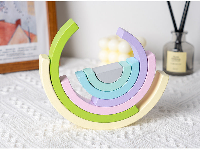 Colorful wooden toy with rainbow design on a textured surface