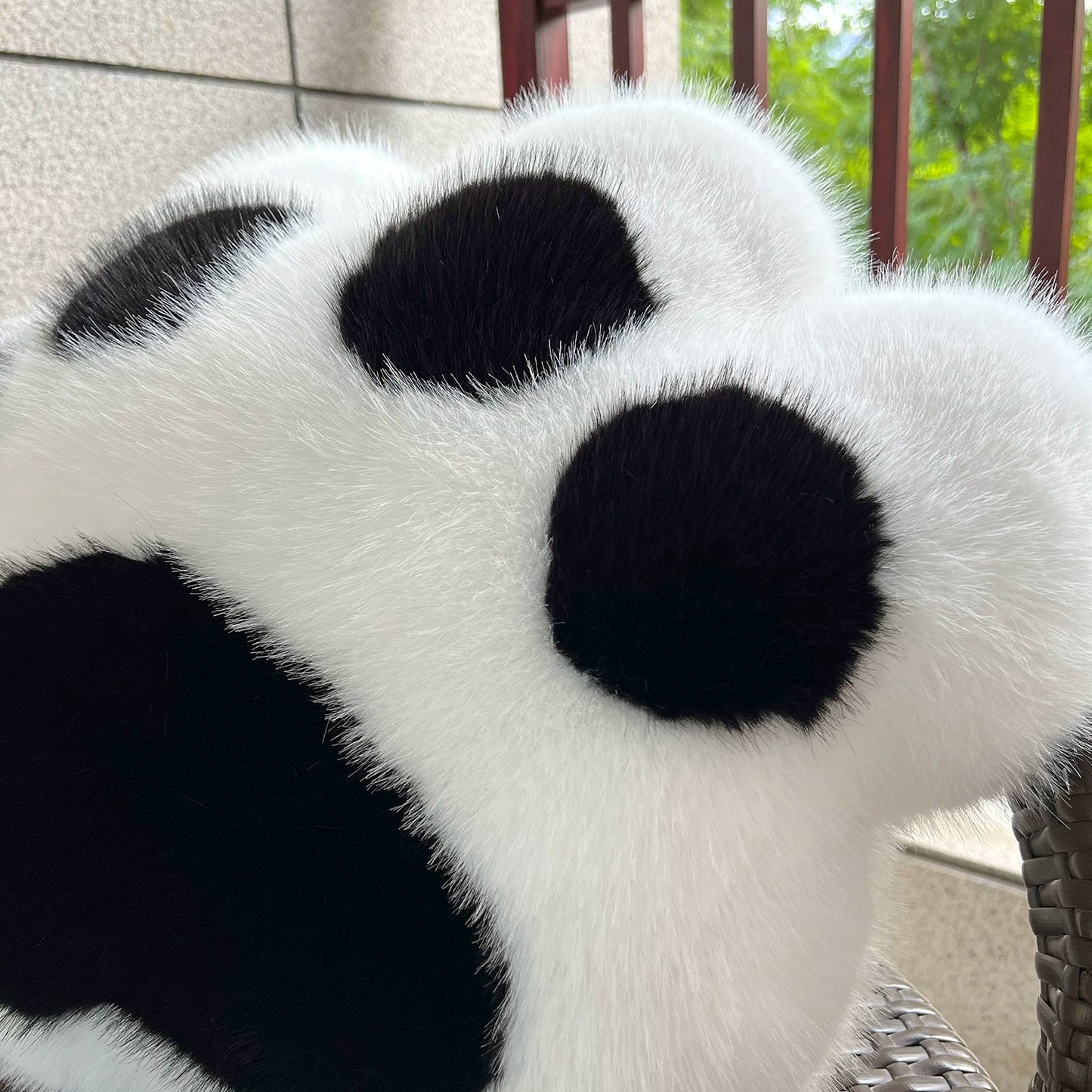 White and black paw-shaped cushion on a chair outdoors.