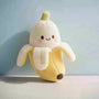 Plush toy shaped like a banana with a smiling face on a light blue background
