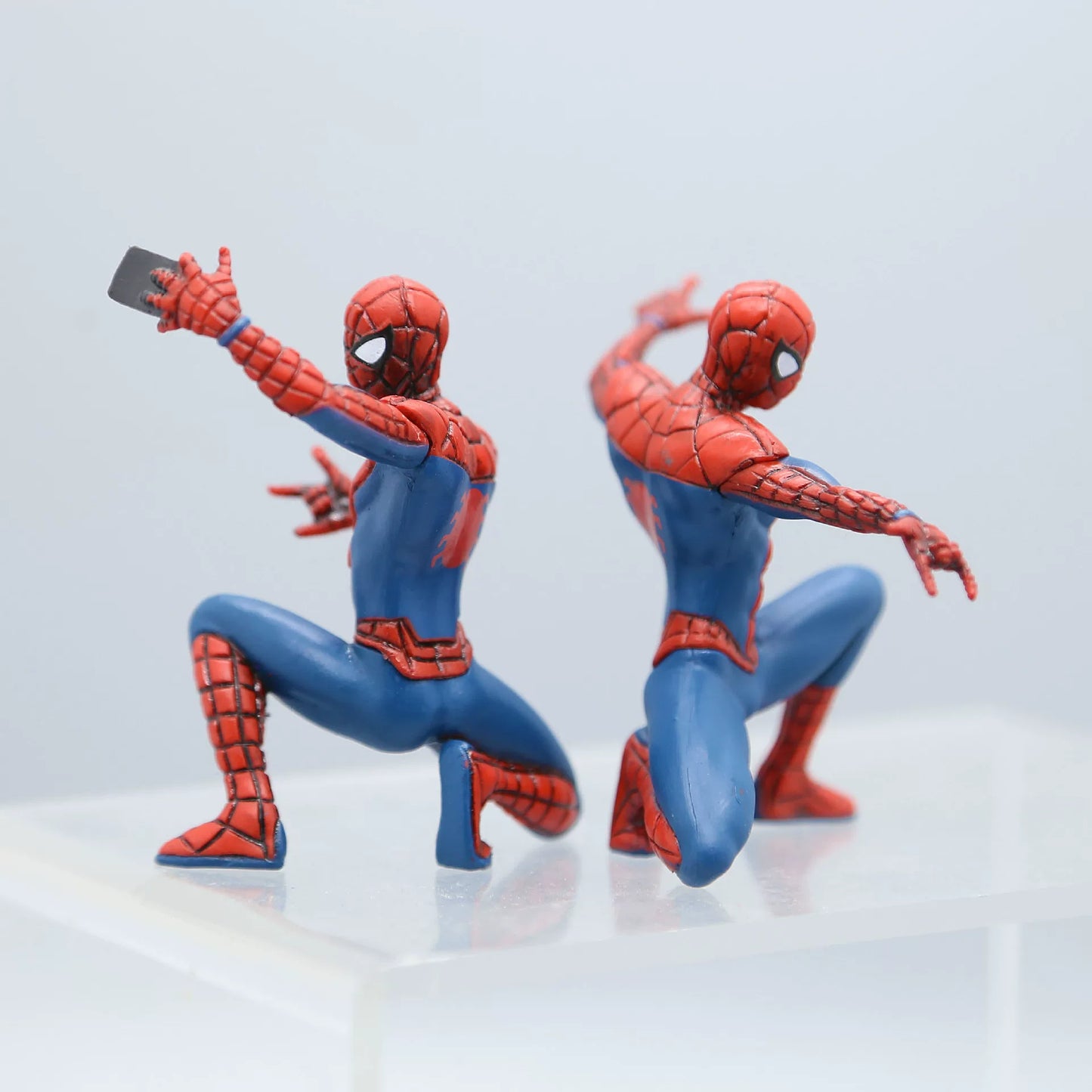 Two Spider-Man action figures on a light gray background