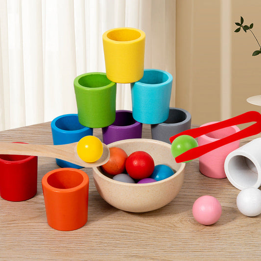 Colorful wooden toy set with cups and balls on a wooden surface