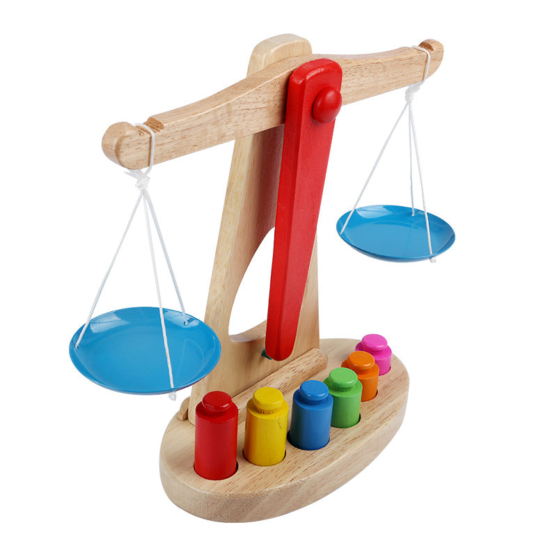 Wooden balance scale toy with colorful weights on a white background