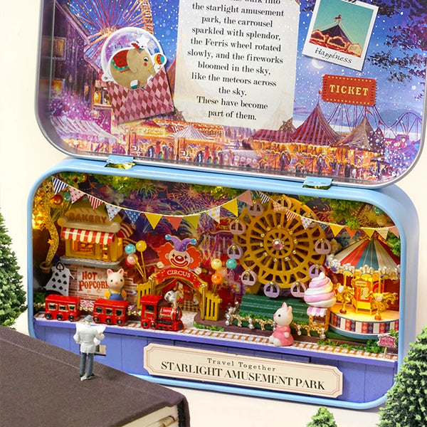 Toy model of a starlight amusement park inside a tin with detailed scenery and figures.