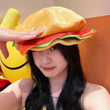 Person wearing a large, colorful hamburger-shaped hat indoors.