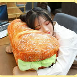 Person hugging a large sandwich-shaped pillow in an office setting