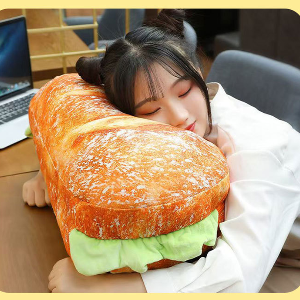 Person hugging a large sandwich-shaped pillow in an office setting