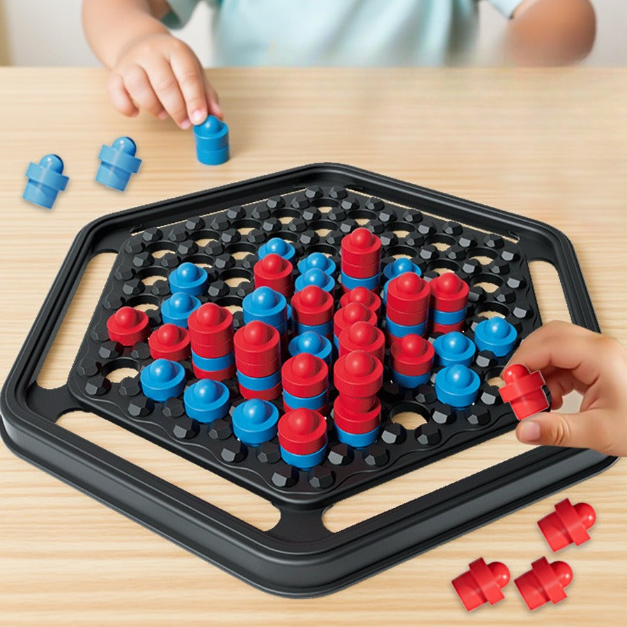 Children playing with a board game involving red and blue pieces on a wooden table.