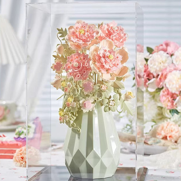 Geometric vase with pink flowers on a clear stand against a blurred floral background