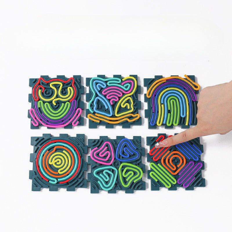 Colorful interlocking foam puzzle mats with hand interacting with one of them on a white background