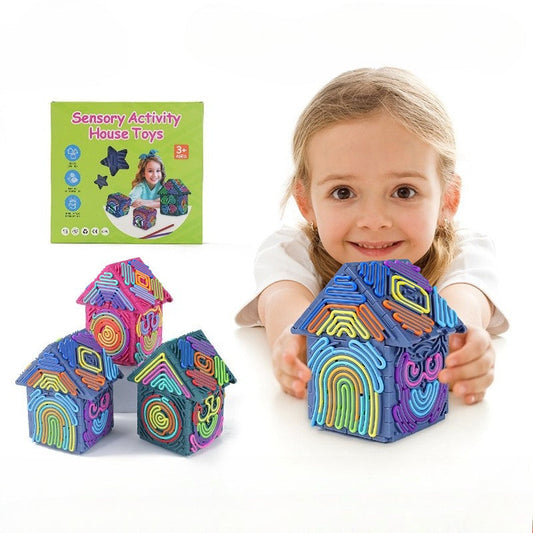 Child holding colorful house-shaped toys with packaging in the background