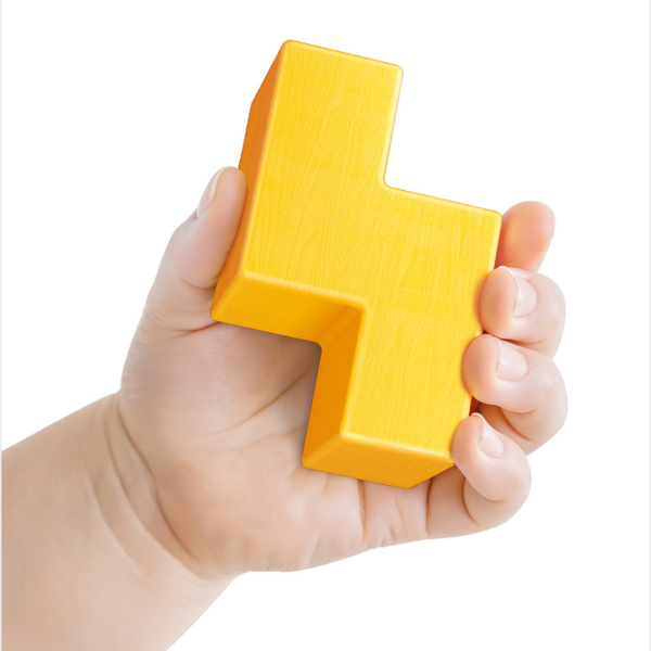 Hand holding a yellow letter 'H' block against a white background