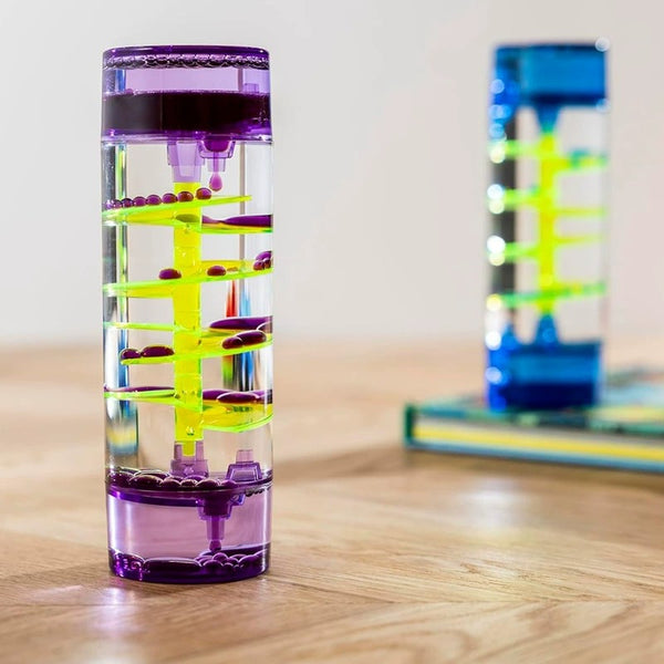Colorful cylindrical water bottle with a unique design on a wooden surface