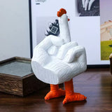 White goose figurine with orange feet and beak on a wooden surface